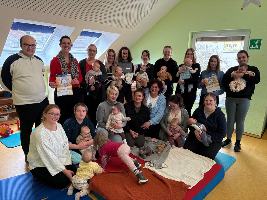 Großer Zulauf beim Café Babyzeit in Büren: Johanna Wodecki (Mitte blaue Jacke) und Melanie Raupach (hintere Reihe – 2.v.l.) inmitten „ihrer“ jungen Eltern samt Nachwuchs. Michaela Jeske (hintere Reihe - 5.v.l.), Mitarbeiterin des Kreisjugendamtes, und Angelika Schmidt, Leiterin des Ev. Familienzentrums „Emmaus“ (hintere Reihe – 2.v.r.), gratulieren zum Jubiläum. ©Kreis Paderborn, Diana Ramme